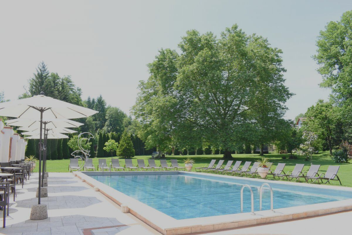 Ein Pool mit Sonnenliegen und Sonnenschirmen rundherum